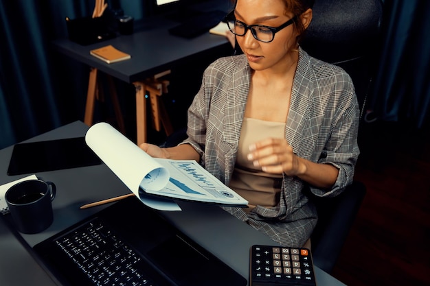 A person using a calculator while reviewing financial documents, representing the process of tax planning and calculation.