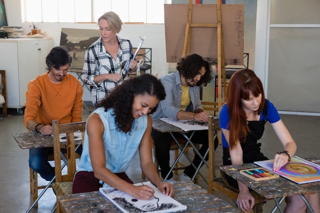 Students from different cultural backgrounds work together on a project, surrounded by artwork and posters representing various cultures.